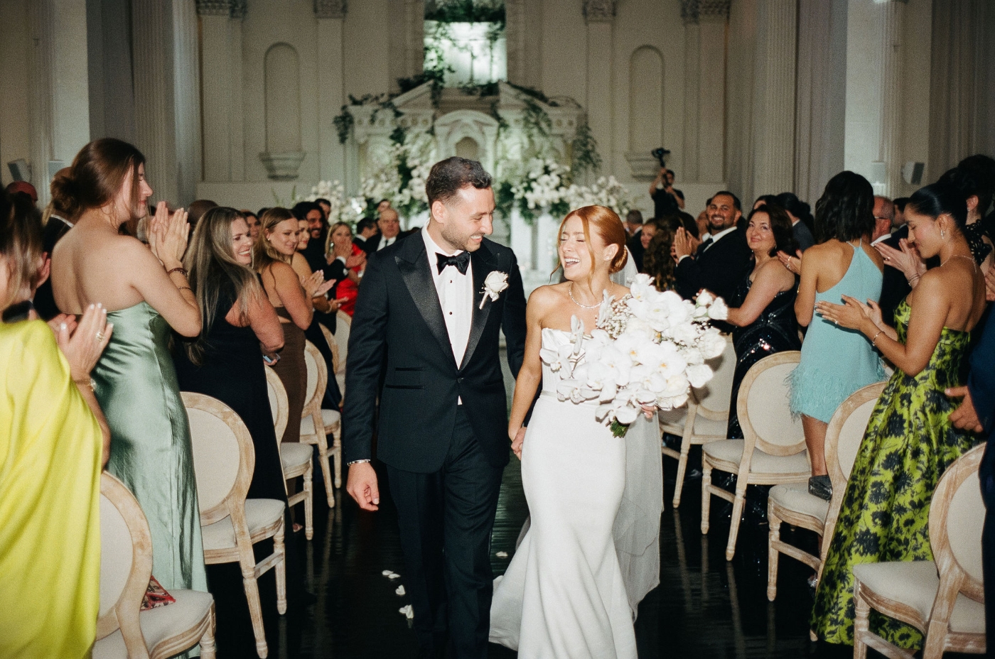 a bride and groom walk down the aisle in a cathedral after their wedding ceremony