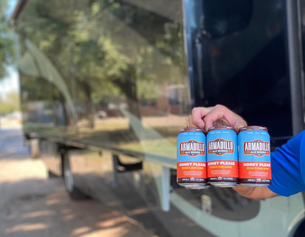 The branding package for Armadillo Ale Works is crisp and clean. The photo shows someone holding a nicely designed 6-pack.