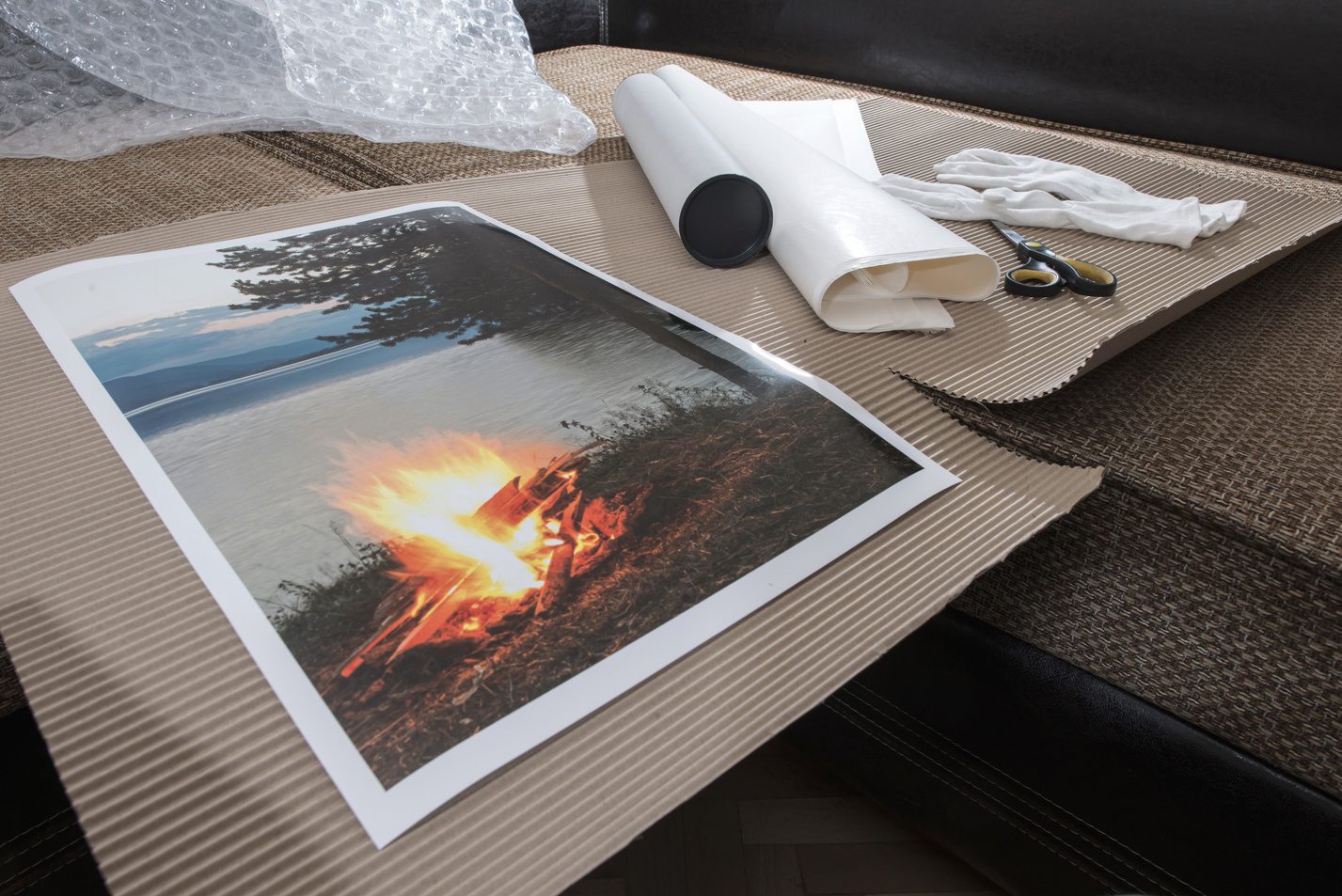 A paper print of a campsite fire being mounted into a frame