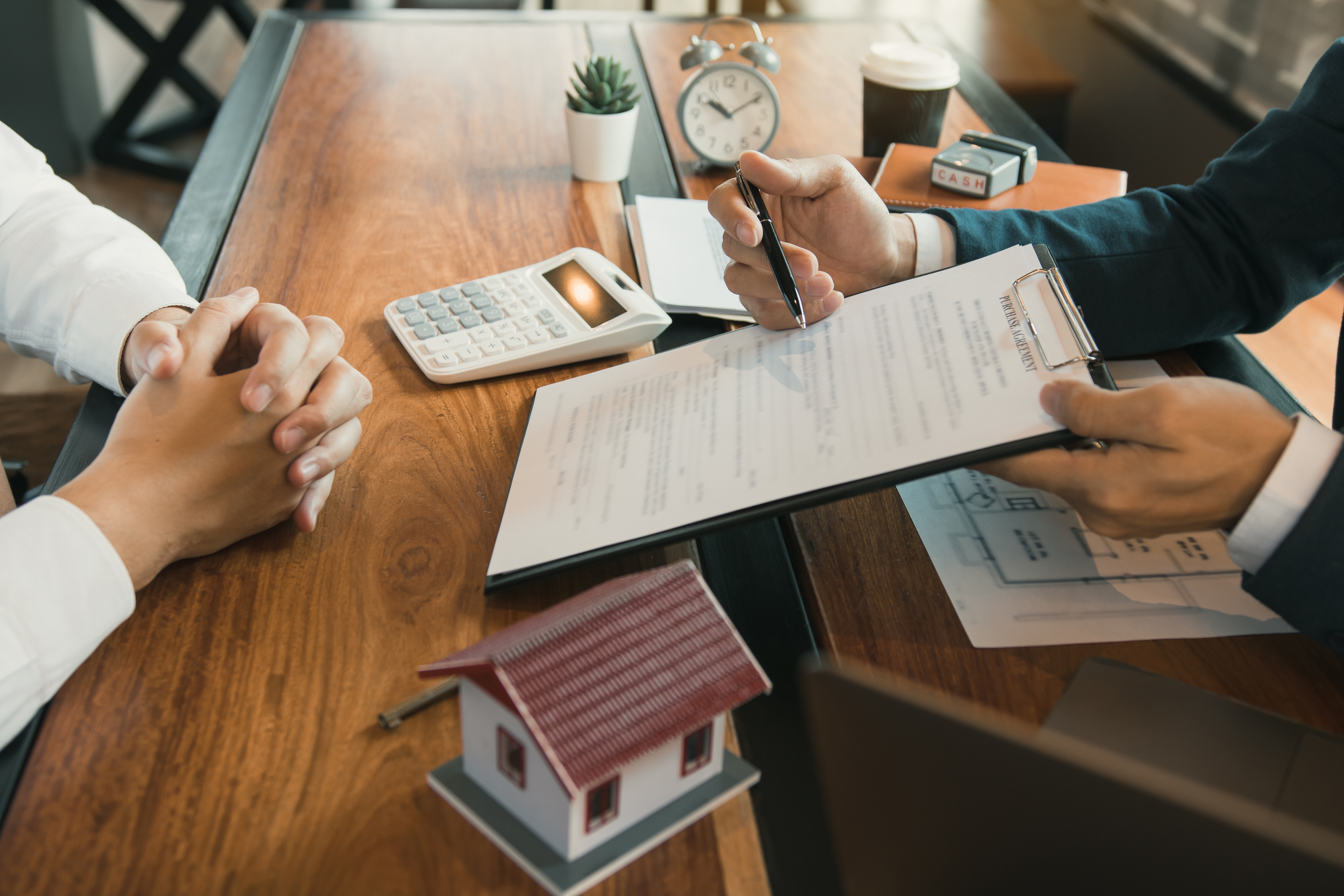 An agent explaining to customers how to sign a contract to buy a new home