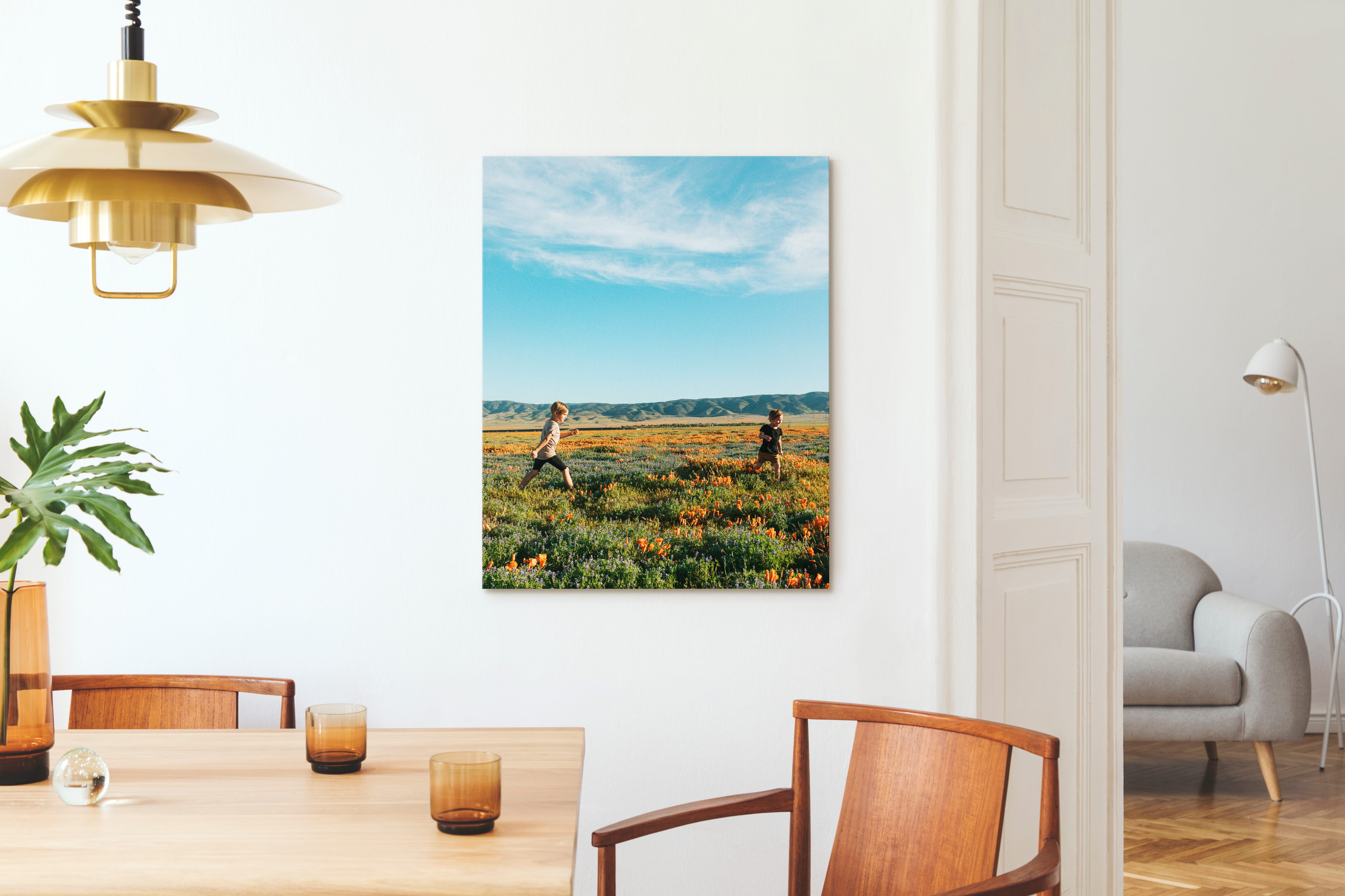 Canvas print in dining room of two children running through a field