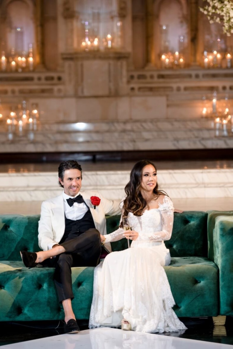 bride and groom sitting on green couch