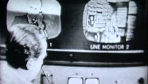 Early black-and-white image of man viewing screen.