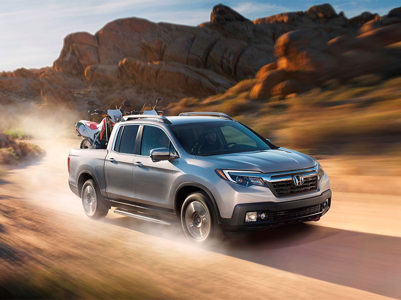 2017 Honda Ridgeline on road with ATVs in  cargo bed ・  Photo by Honda 