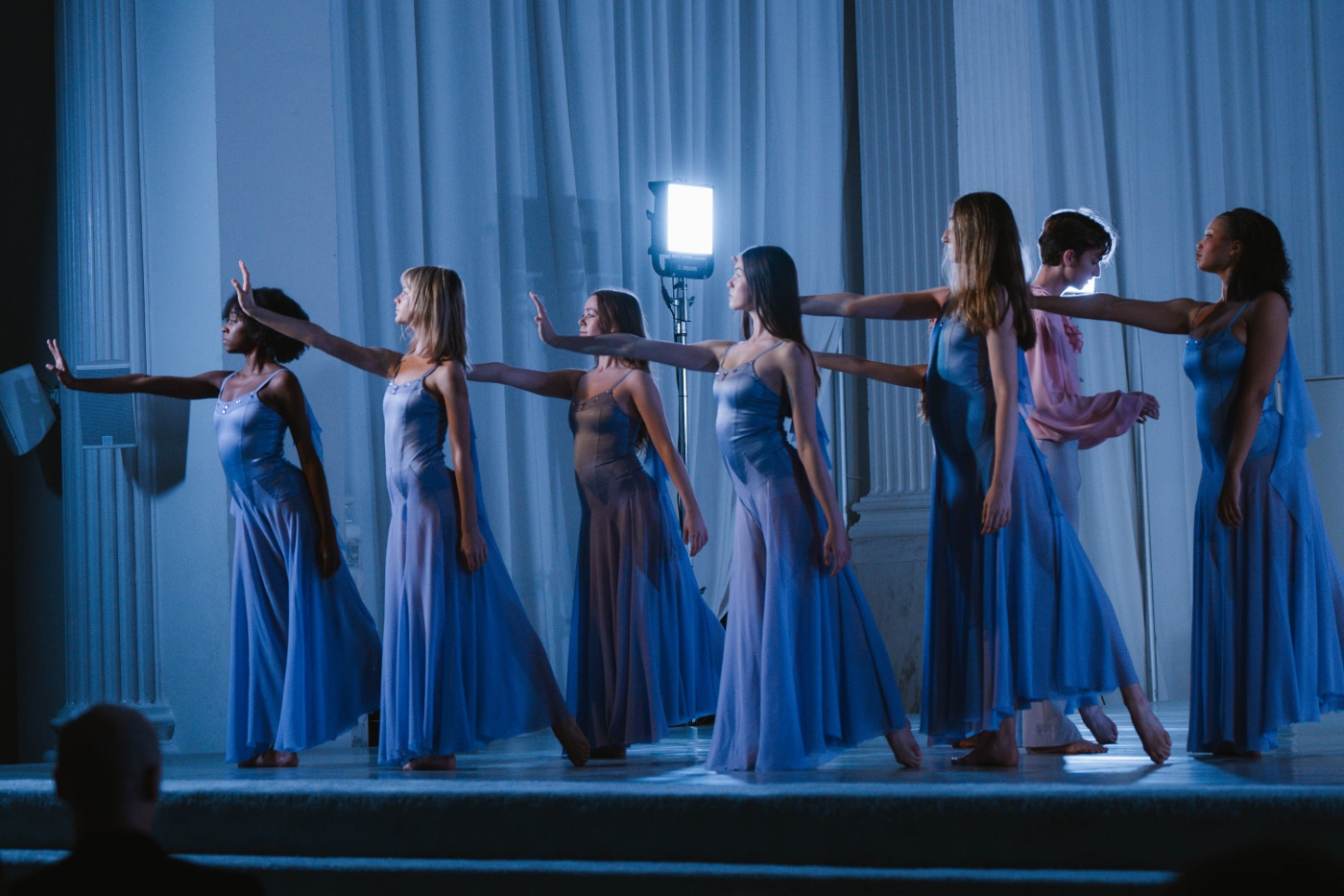 a group of female dancers in blue gowns onstage, outstretching their palms offstage at a performance at Vibiana in Downtown Los Angeles