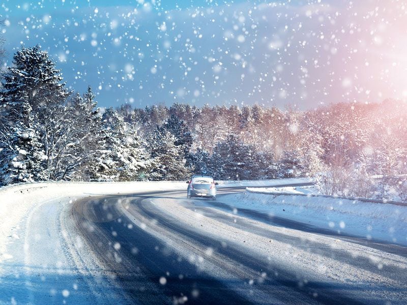 driving in blizzard car on road in snow ・  Photo by Bigstock 