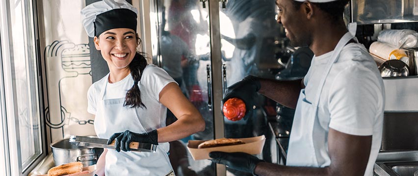 Food truck workers serving customers with a smile