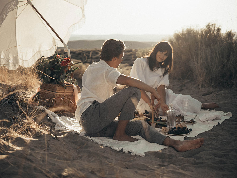 couple having picnic on sandy beach