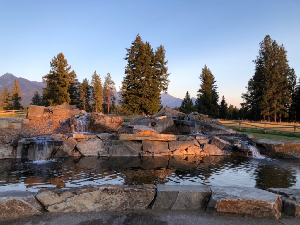 A pond and waterfall feature sit in front of the mountains at Silver Knot.