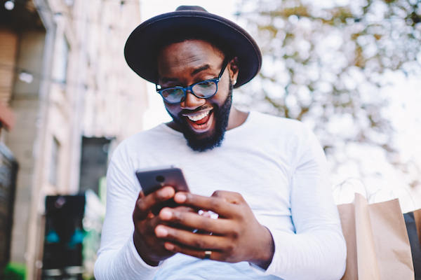 excited african american male getting google alerts on cell phone