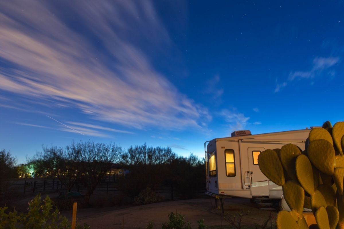 An RV boondocking in a desert setting, one of the best ways to save on RV travel