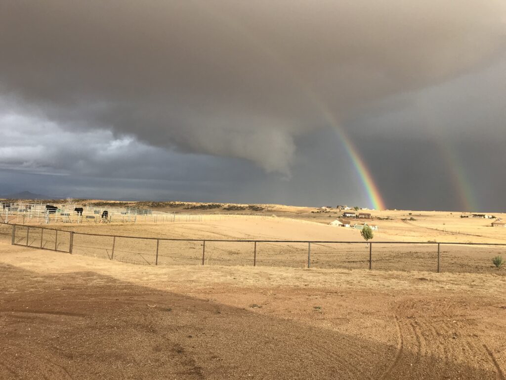 A double rainbow contrasted against the desert farm lands