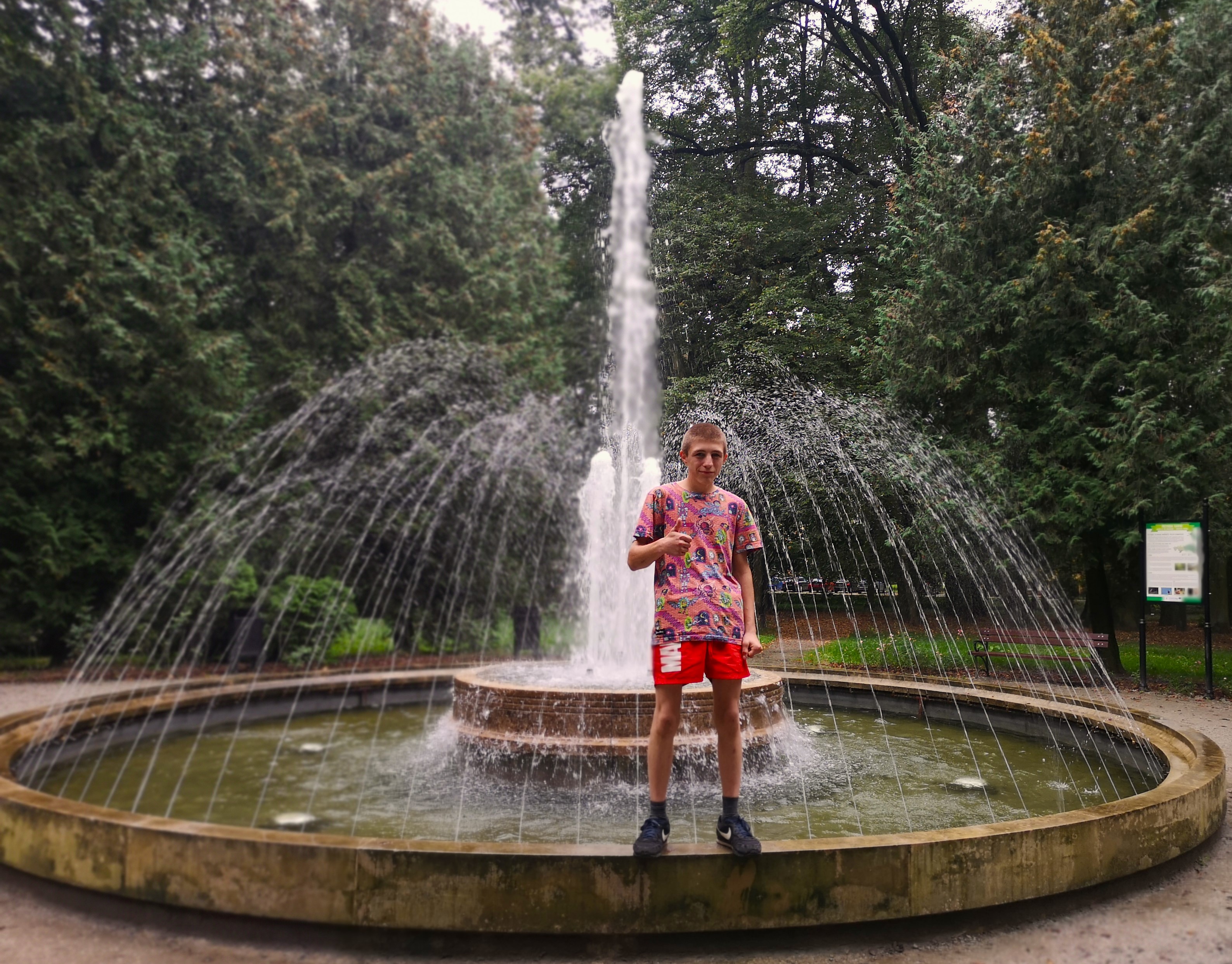 Wycieczka do Jarosławia. | Wychowanek MOW stojący na brzegu fontanny, w tle tryskająca woda oraz drzewa..jpg