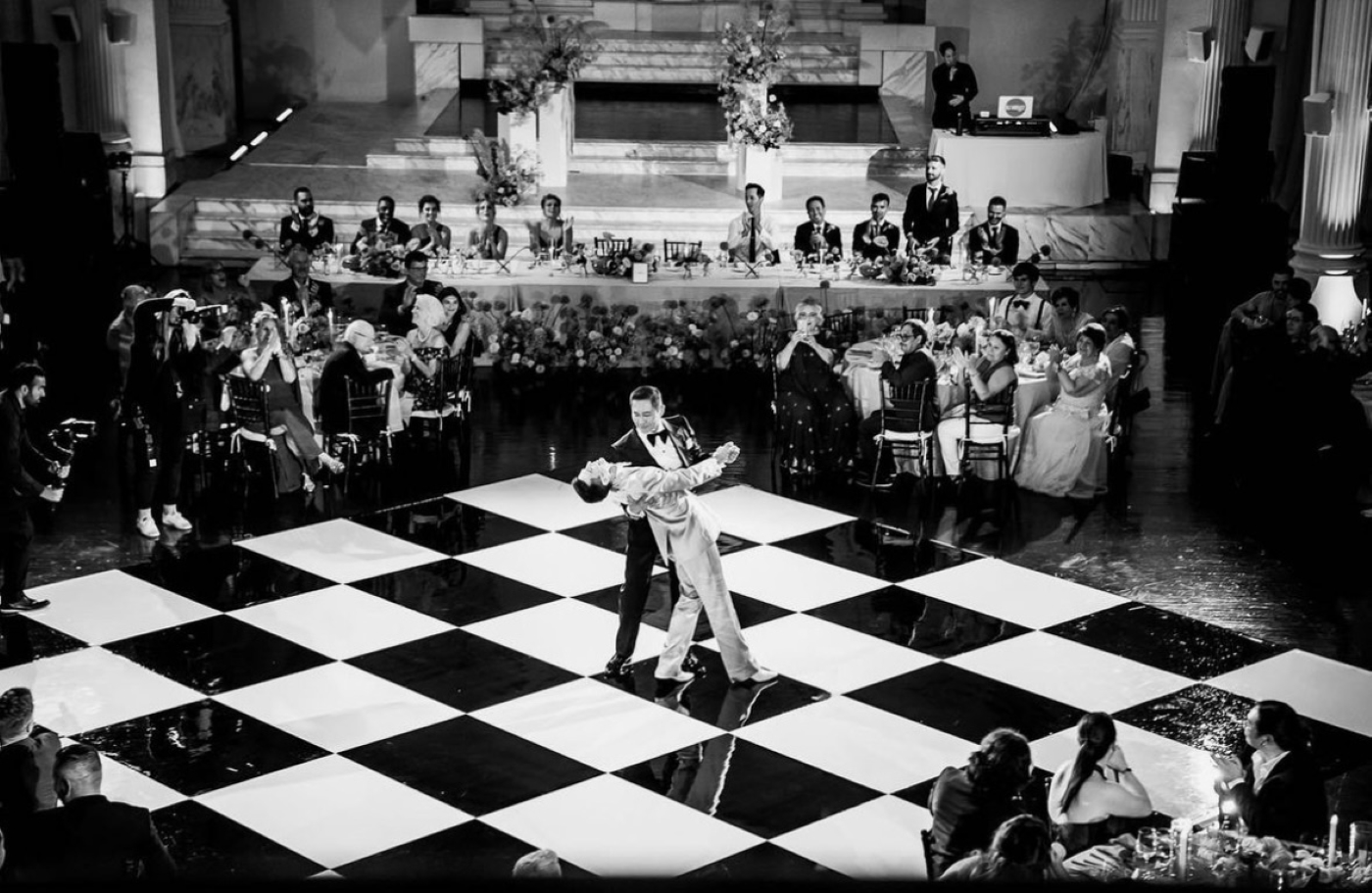 two grooms dancing on black and white floor