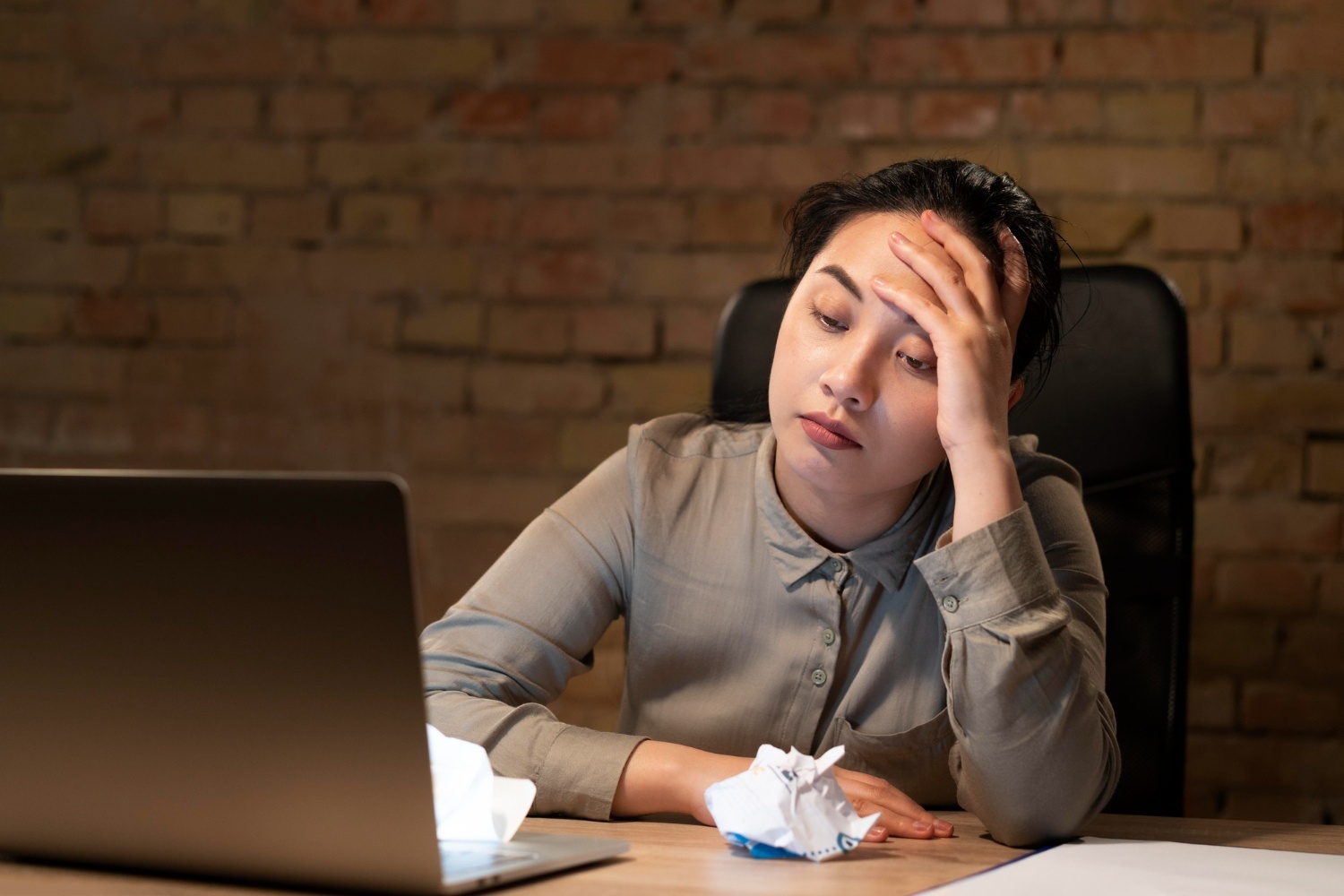 Seorang karyawan wanita merenung karena menghadapi mental block di depan laptop. (Image by Freepik)