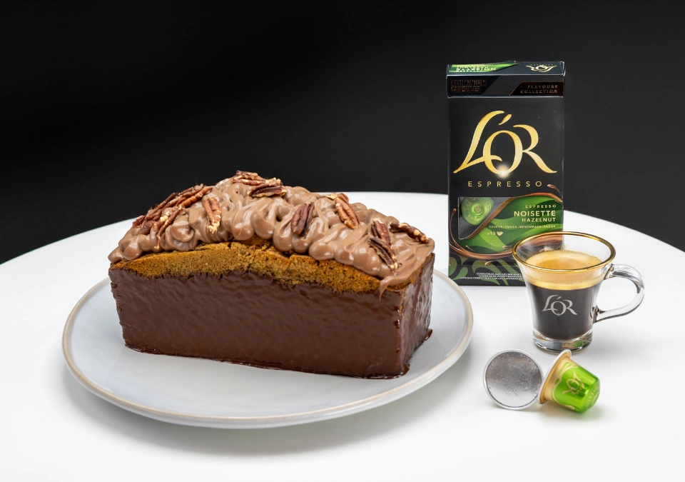 Enhance the visual appeal of a Chocolate cake, espresso pod, and coffee cup on a white surface by incorporating L'OR or L'OR Espresso.