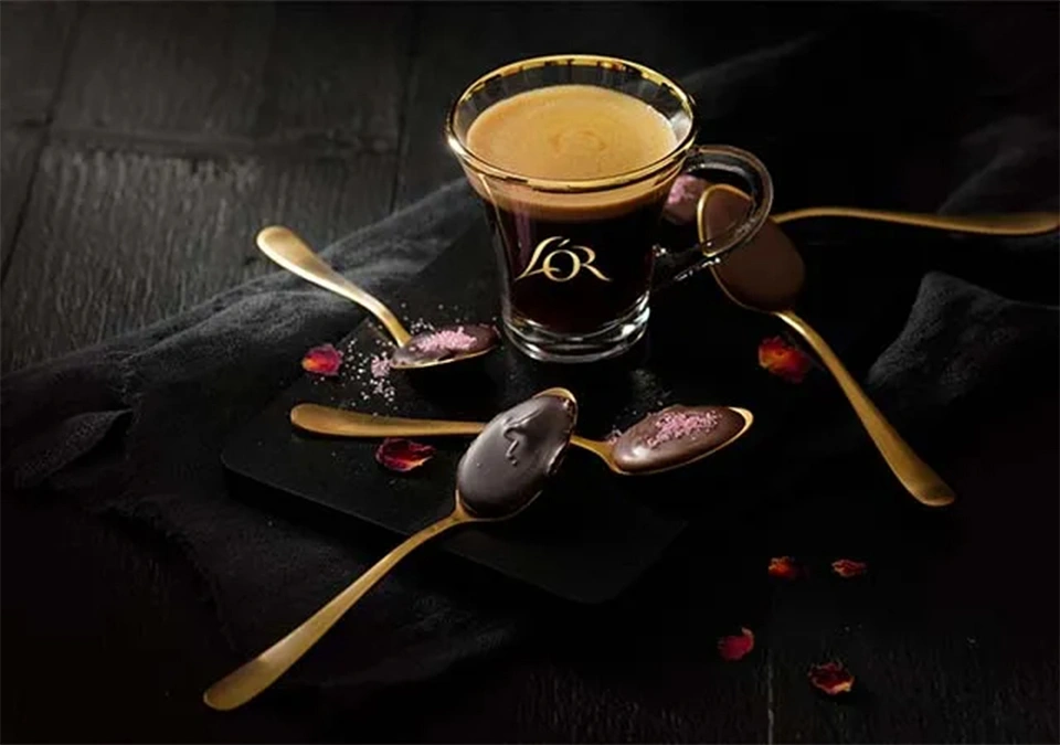 L'OR Espresso paired with chocolate spoons on a dark backdrop for a luxurious experience.