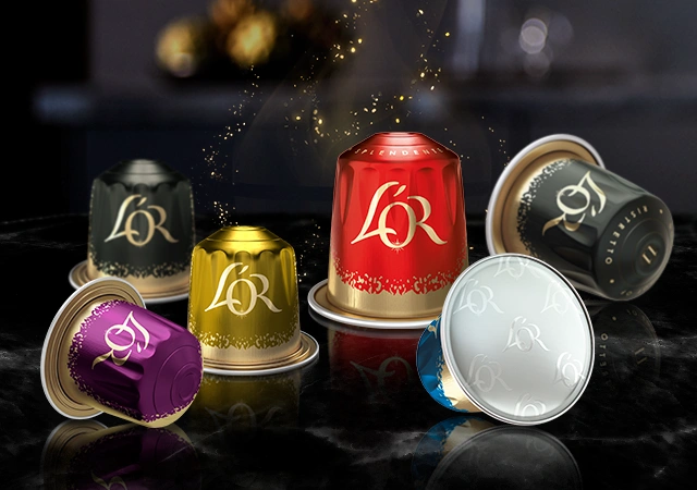 Colorful L'OR Espresso capsules on a shiny black surface, arranged for a striking display.