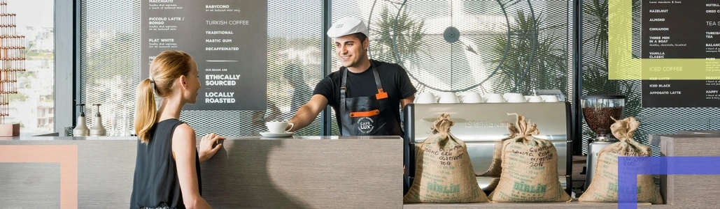 A barista giving coffee to a customer in a cafe