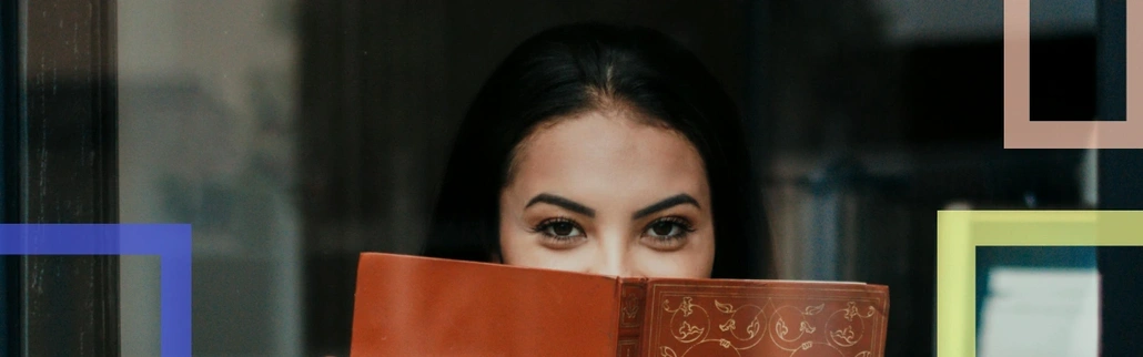 A person hiding behind a book 