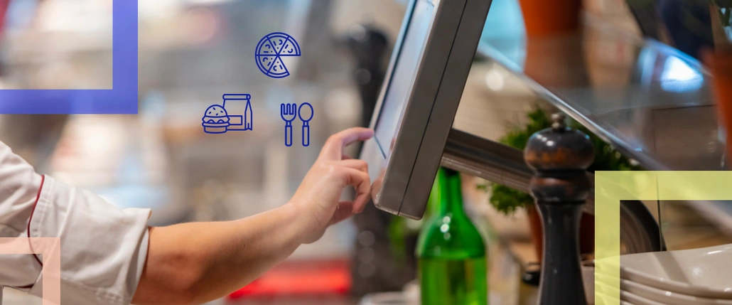 A cook's hand touching a kitchen display's screen and icons of pizza, burger and fork with spoon