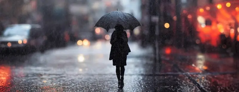 Dark figure walking in the rain with an umbrella