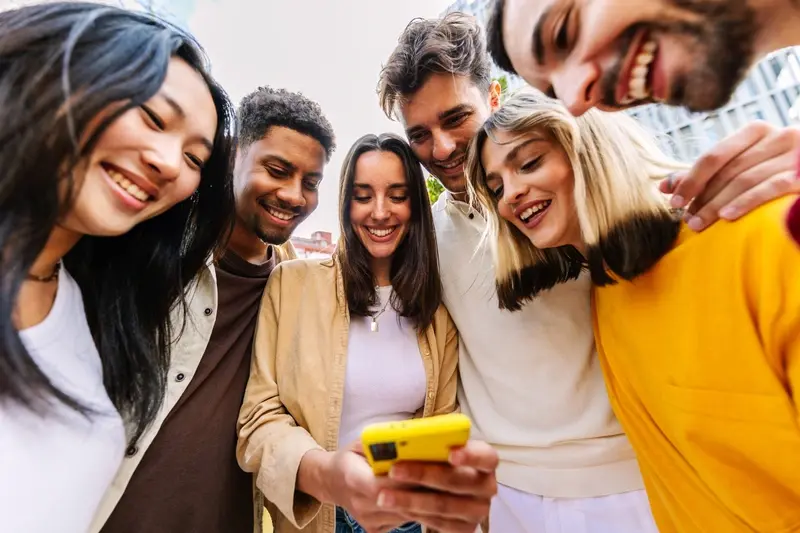 Young people gathered around a device