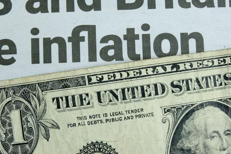 Dollar bill below inflation newspaper headline