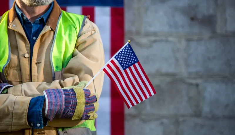 US worker carrying a US flag