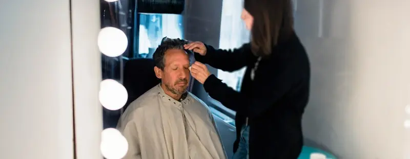 Actor getting make up done in a make up trailer