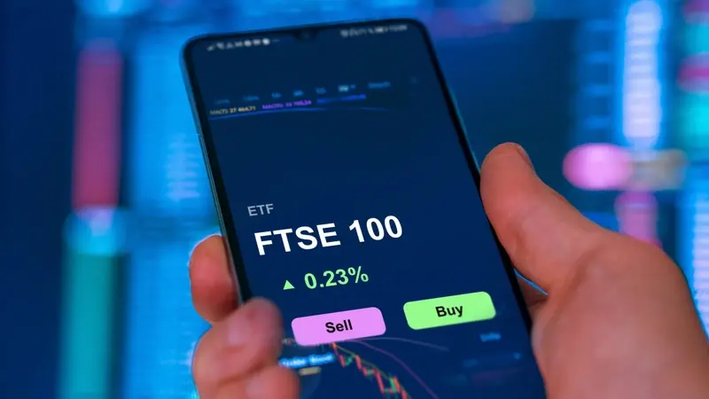 Hand holding mobile with FTSE 100 app open