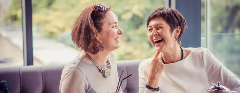 Two women in their 50's laughing