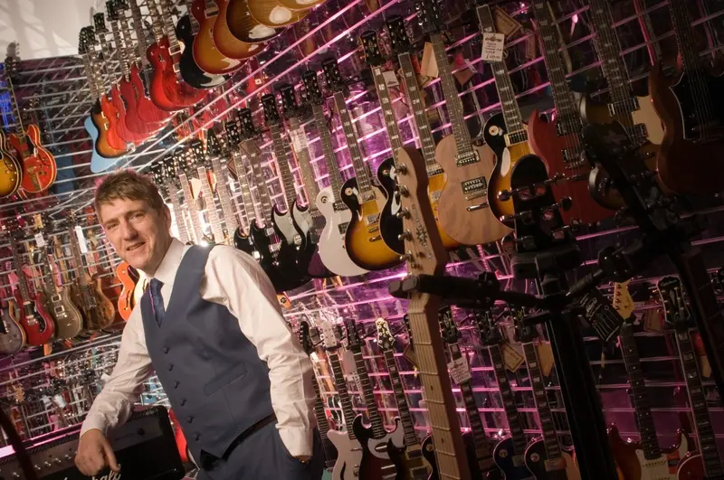 CEO Andrew Wass surrounded by guitars