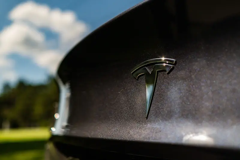 Tesla badge on back of grey EV