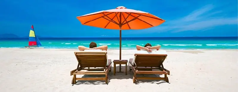 Couple on beach on deckchairs