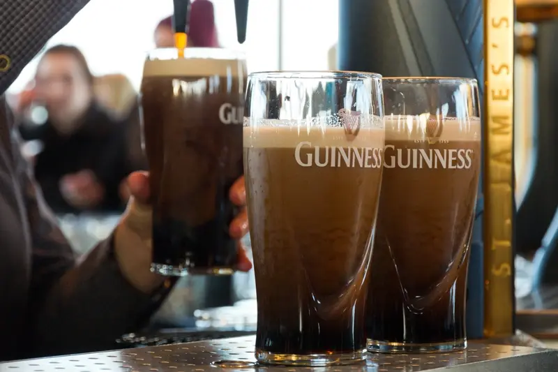 Bar staff pouring pints of Guinness