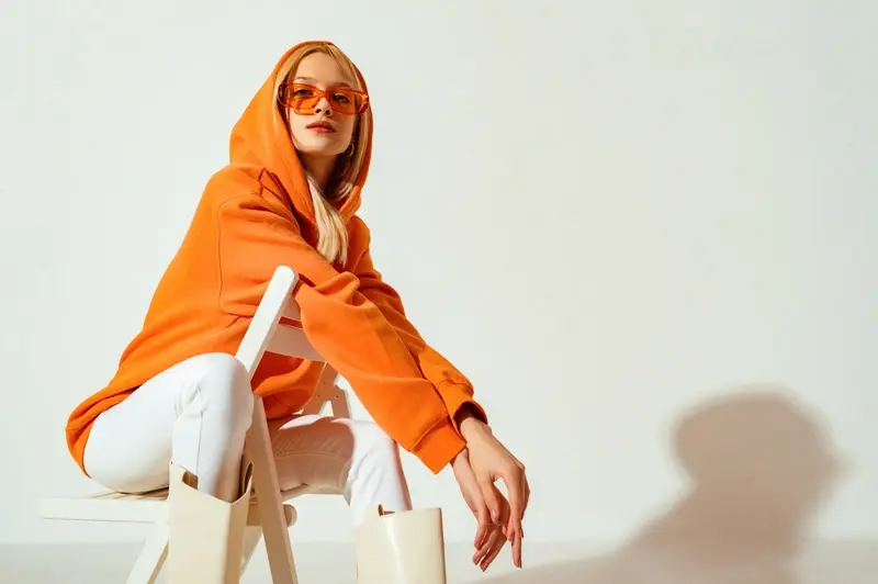 Young person modelling a bright orange hoodie