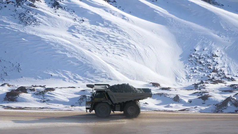 The image shows a mining vehicle set against a snowy backdrop