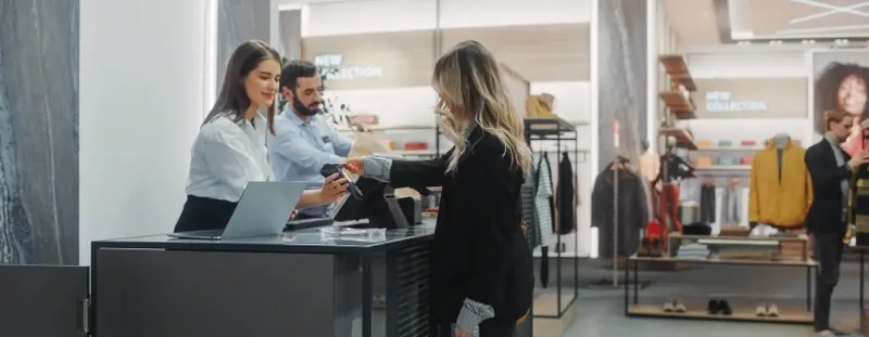 Woman buying clothes from cashier
