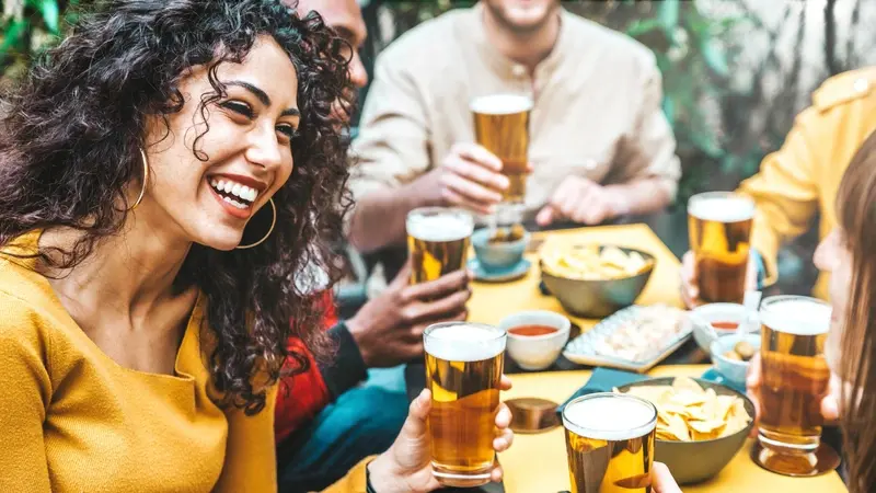 Woman with friends drinking in pub garden