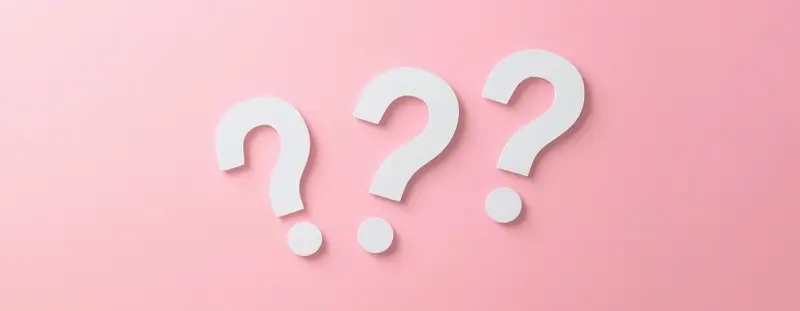 three question marks on a pink background