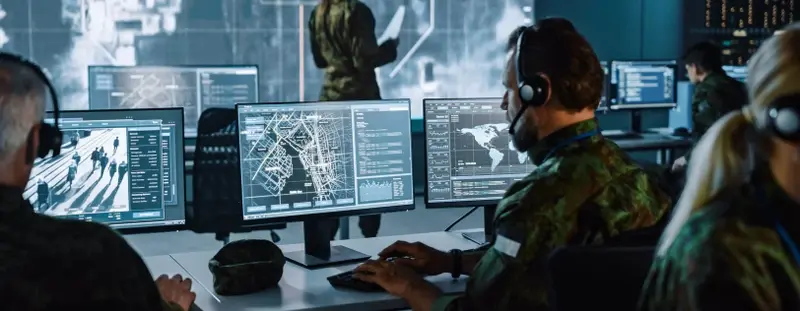 Military using computer wearing a headset