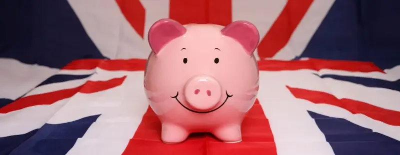 Piggy bank with a UK flag behind it 