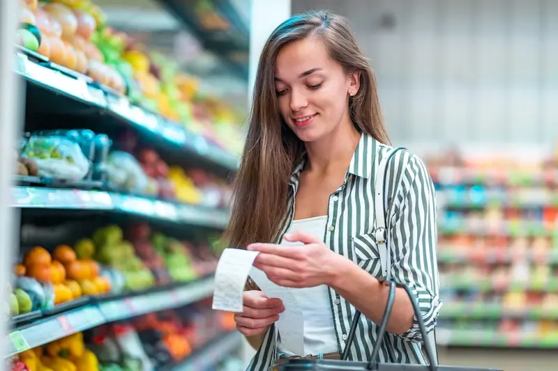 Pleased female shopper looking at supermarket bill