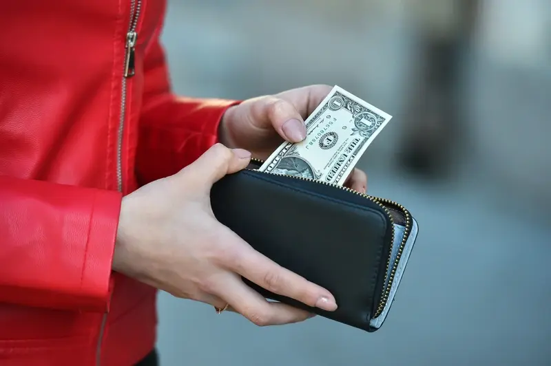 Man pulling dollar bill out of wallet