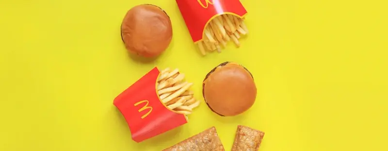 Mcdonald's burger and fries against a yellow background