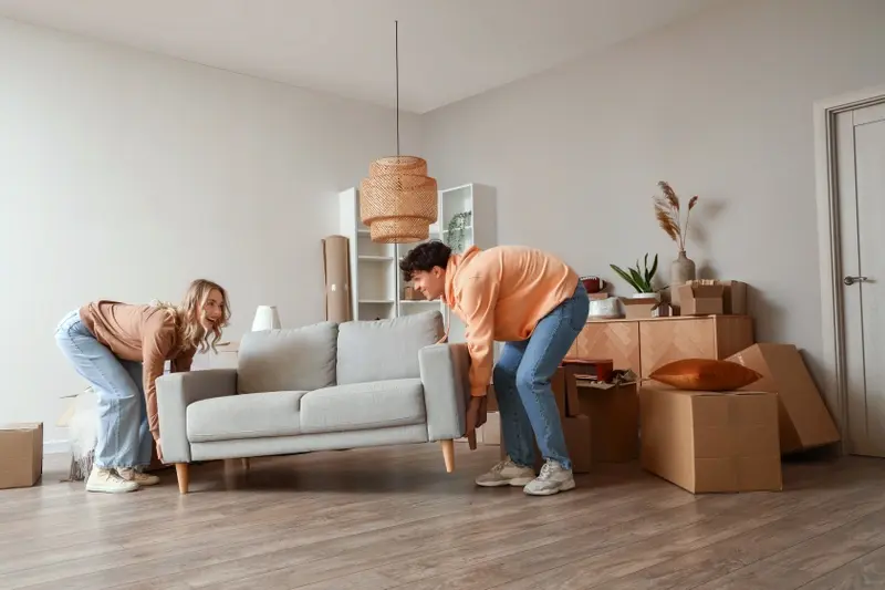 Young couple moving a sofa 