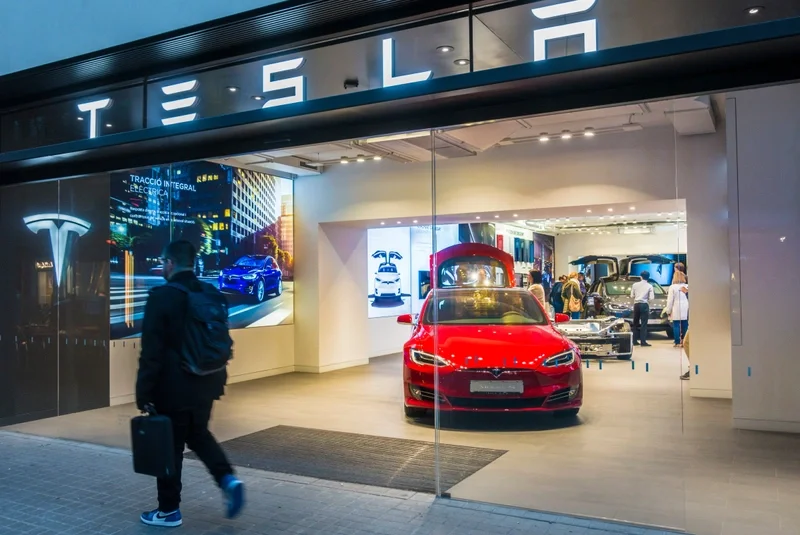 Man walking past Tesla showroom