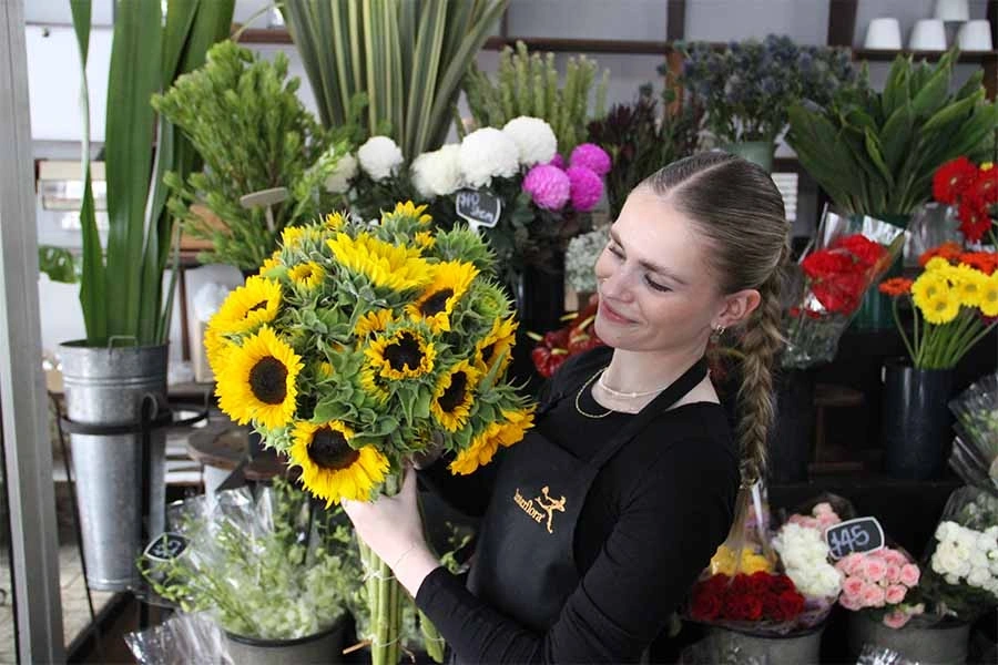 Florist arranging a bouquet of Sunflowers.