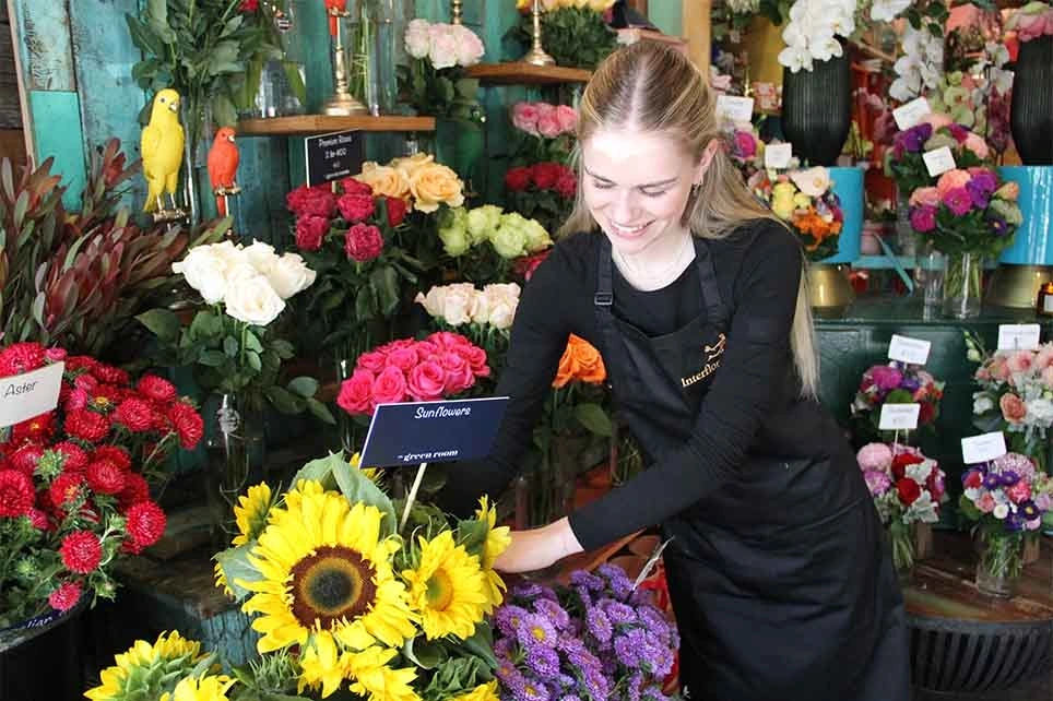 A florist working on flower product placements in her flower shop.